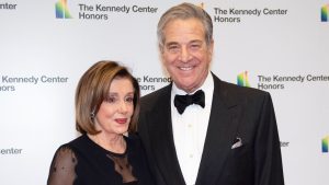 Napadnut suprug Nancy Pelosi Paul Pelosi na slici sa suprugom Nancy Pelosi on u crnom odijelu leptir mašni i bijeloj košulji ona u cnroj čipkanoj haljini iza zid na kojem piše The Kennedy Center