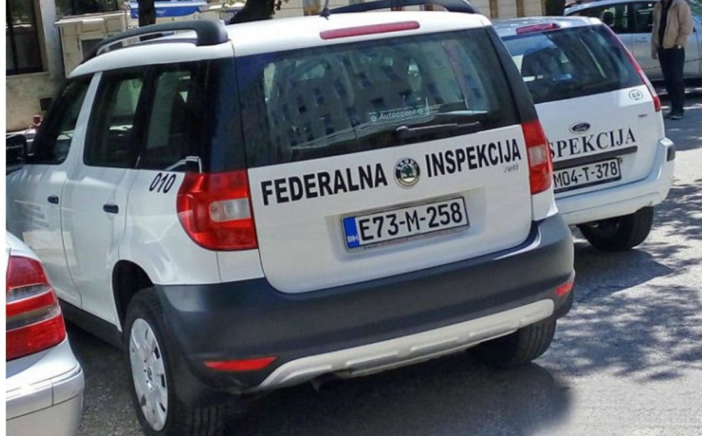 velika akcija inspekcije dva automobila marke škoda bijela sa natpisom federalna inspekcija crnim slovima slikani odzada pakirani na ulici sunčan dan