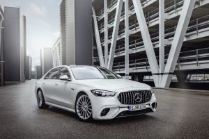 Mercedes predstavio najjaču S klasu bijeli Mercedes na ulici između zgrada koje izgledaju futuristički sa bijelim željeznim stubovima u pozadini zgrade u magli automobil se vidi sprijeda veliki znak mercedesa na rešetki za hladnjak ne vidi se vozač dan