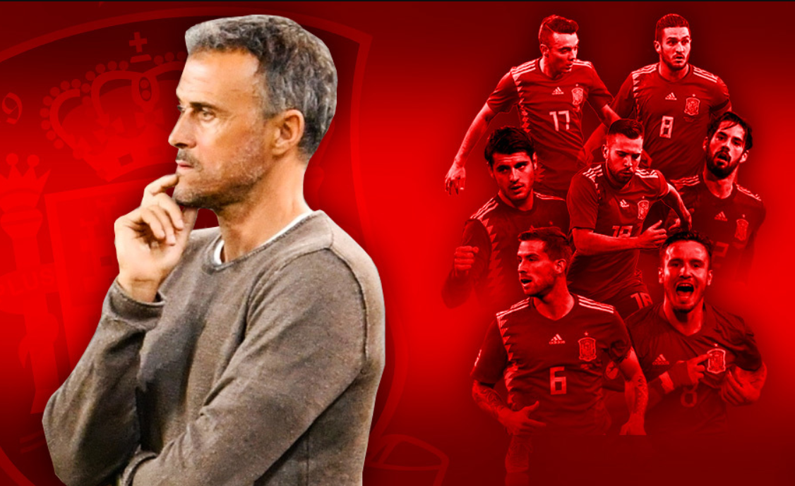 Luis Enrique u sivom džemperu ispod viri bijela majica ikrenut leđima reprezentativcima koji su stavljeni jedan iza drugog u crvenoj boji crvena podloga Enrique drži prst na bradi izgleda zabrinuto ilustracija